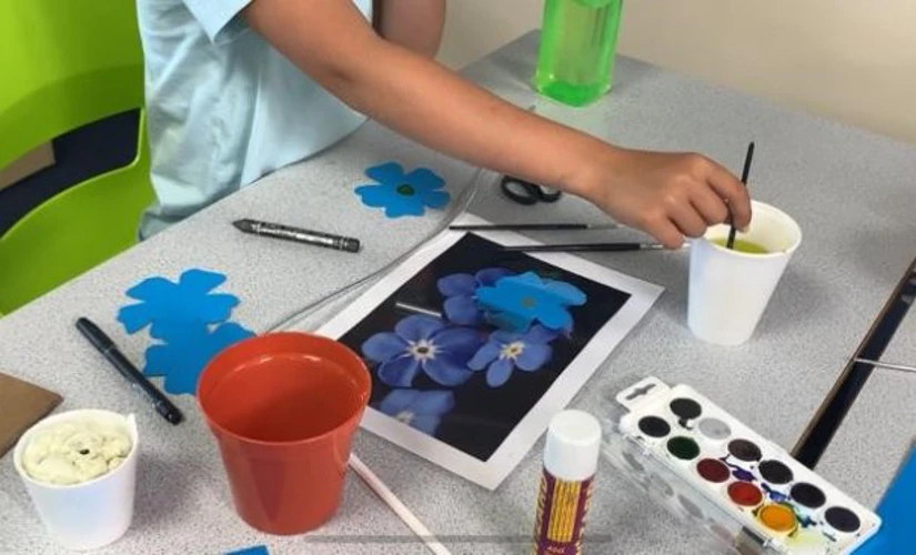 child painting a flower