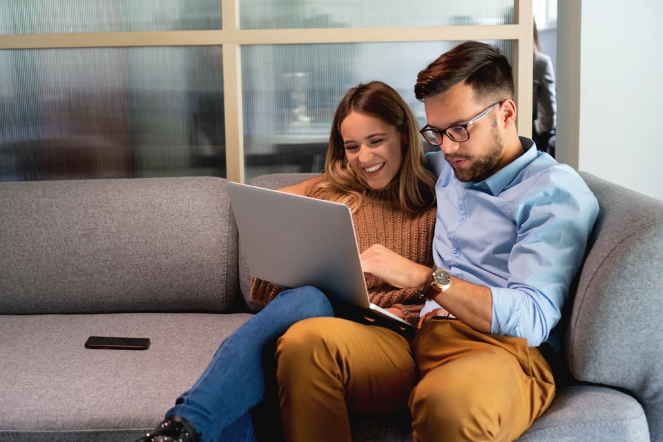 Happy man and woman using a laptop