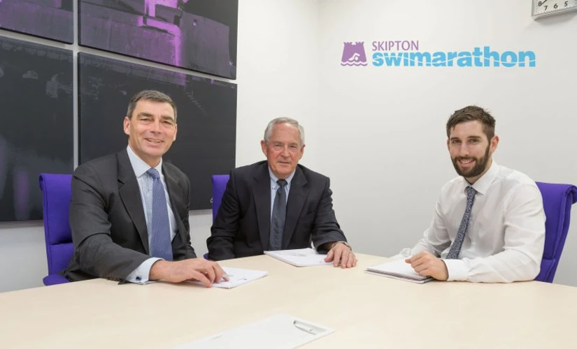 men smiling sat down in meeting room