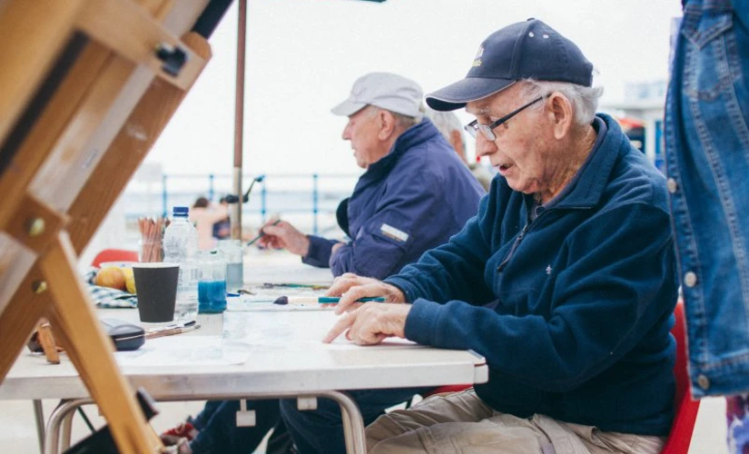 men painting on sea front