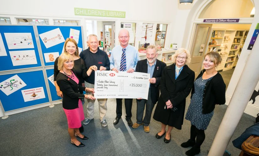 people smiling with large cheque