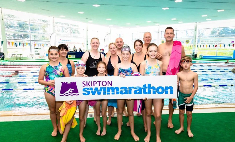 Group of swimmers posing with Skipton Swimarathon logo
