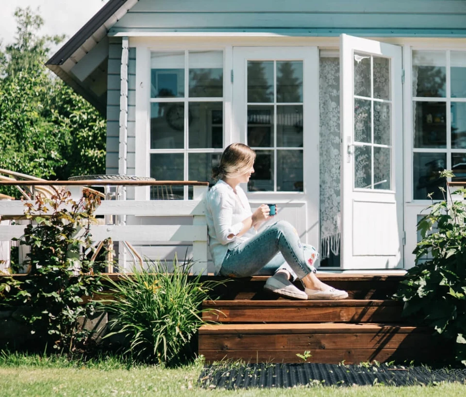 Lady with coffee sitting on her front porch