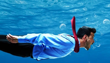 man in suit swimming underwater