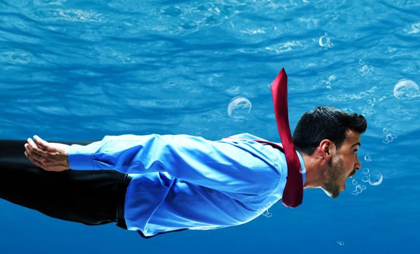 man in suit swimming underwater