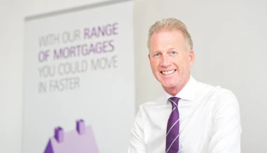 man smiling next to Skipton logo