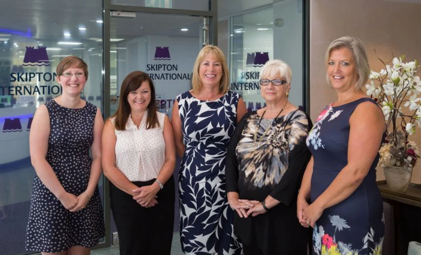 Five women photographed in Skipton International Limited's lobby