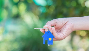 people holding keys with house keychain