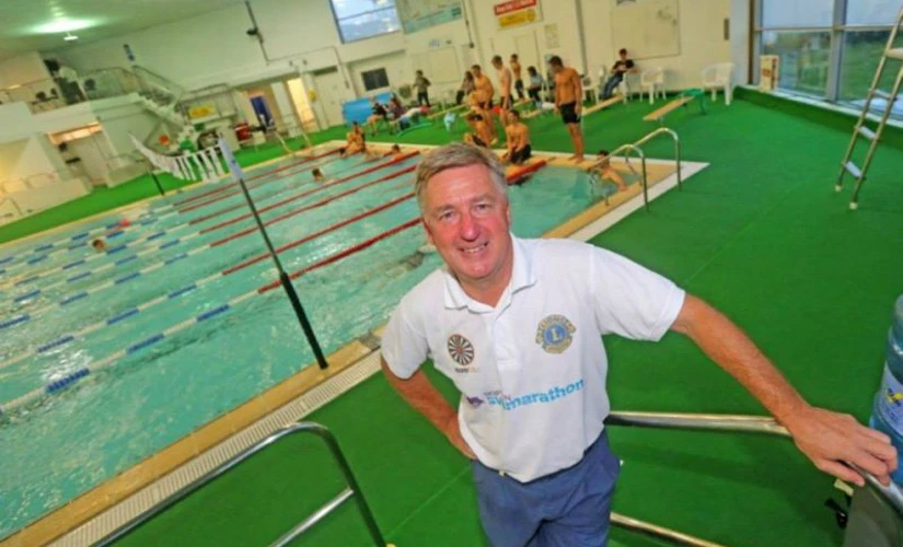 Man smiling next to swimming pool